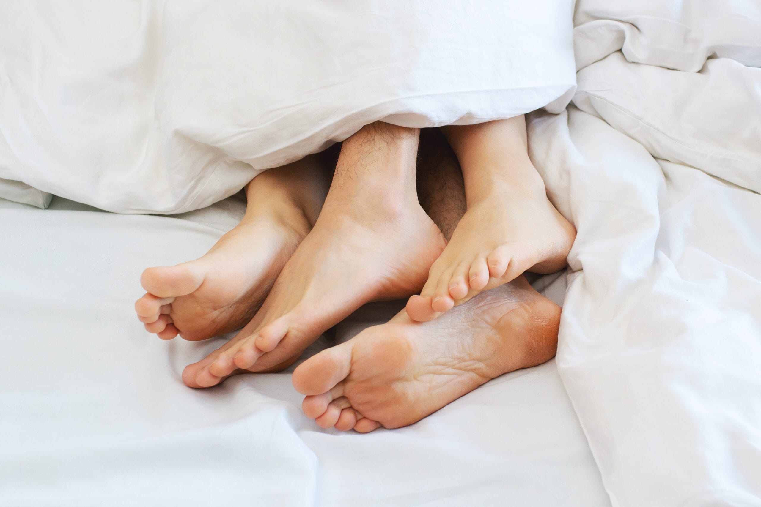 Young,Couple,Making,Sex,Under,Blanket,In,Bedroom.,Sleeping,Spouses shutterstock 1330390250 scaled